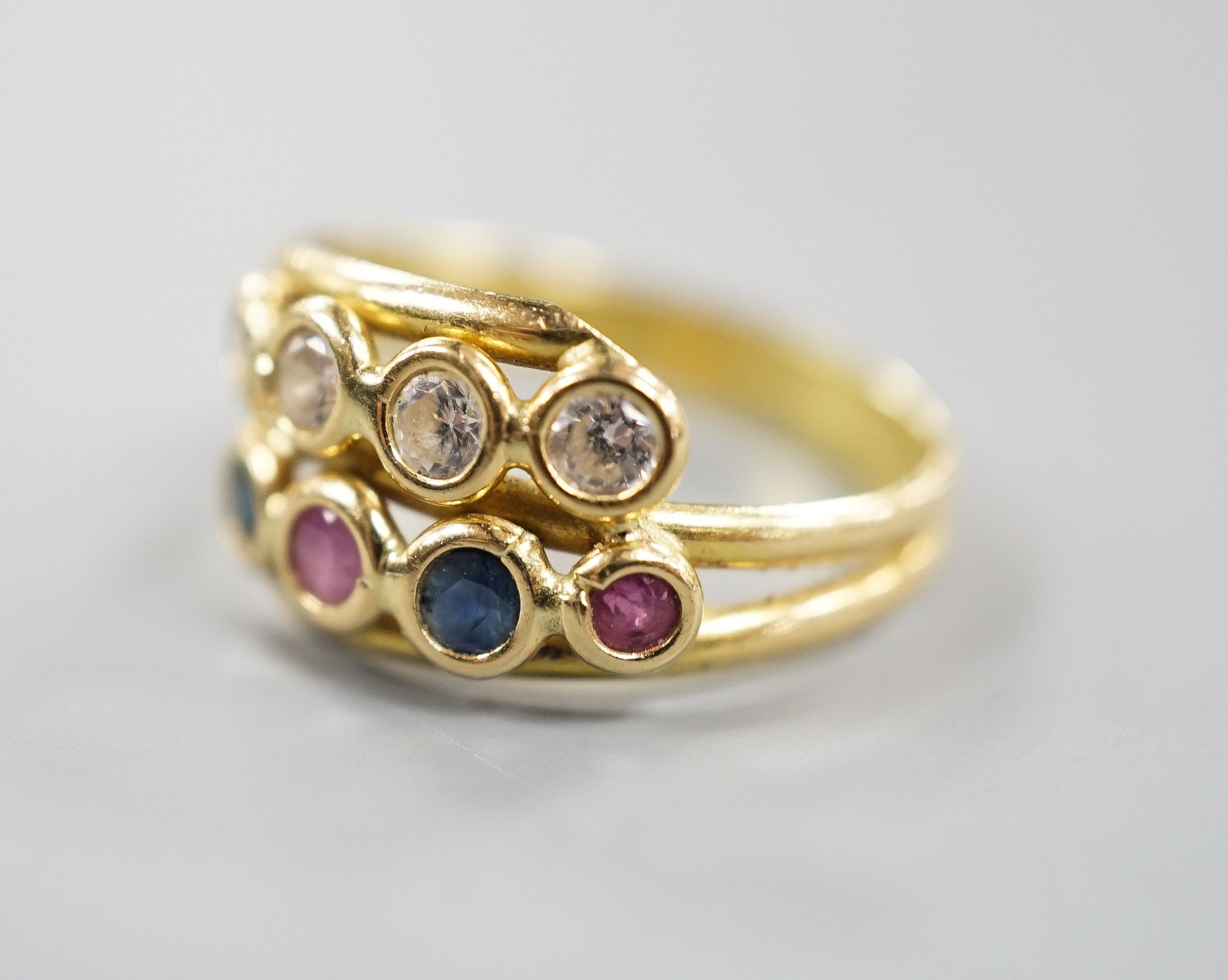 A modern Italian 750 yellow metal and collet set four stone diamond, two stone sapphire and two stone ruby set two row ring, size J/K gross 2.8 grams.